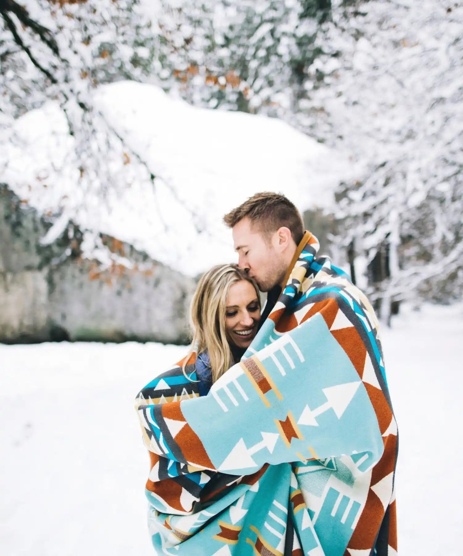 Couple confortable enveloppé dans une couverture à motifs.