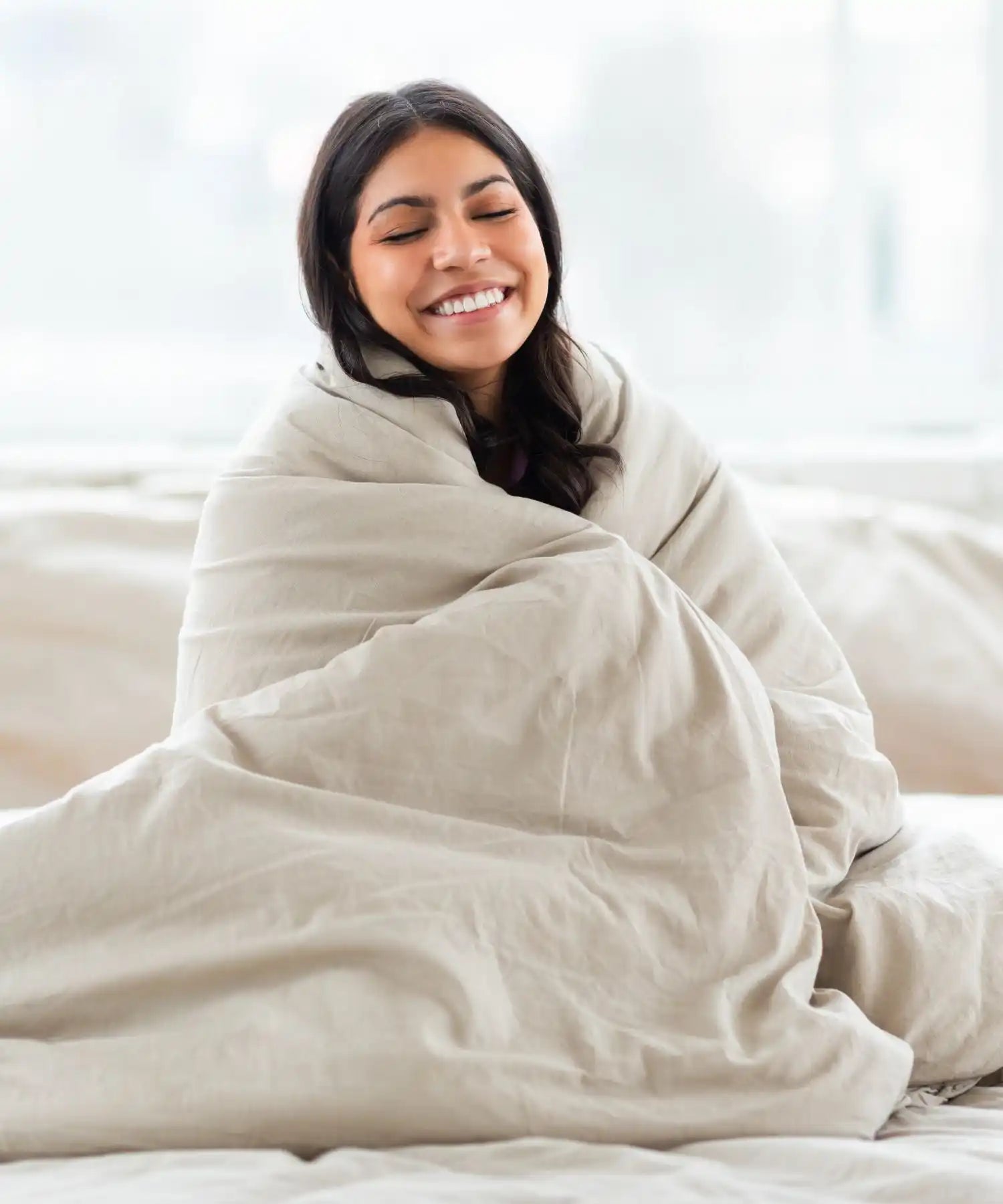Femme confortable enveloppée dans une couverture.